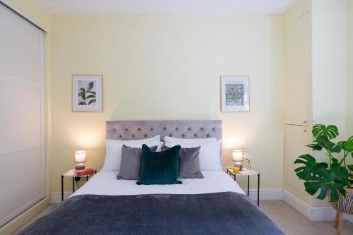a bedroom with a large bed with a green pillow at Prime Location Cardiff Pontcanna Modern 2 Bedroom Apartment with Privat Parking in Cardiff