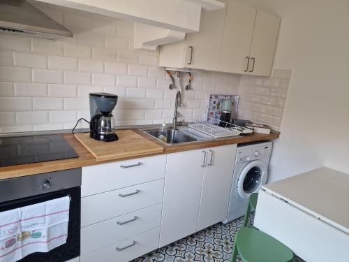 a kitchen with a sink and a washing machine at Alojamento Mercado Norte in Lisbon