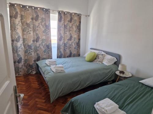 a bedroom with two twin beds and a window at Alojamento Mercado Norte in Lisbon