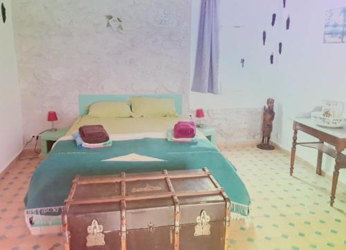 1 dormitorio con 1 cama con tronco de madera en Dar De La Milonga, en Essaouira