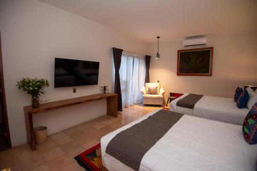 a hotel room with two beds and a flat screen tv at Nardazul "Casa de Sueños" in Oaxaca City