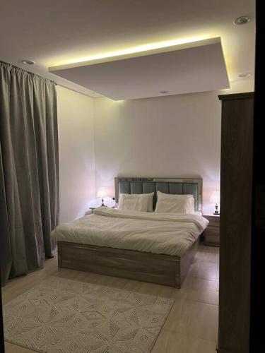 a bedroom with a large bed with two lamps on it at سُكْنَى خصوصية عائلية بفخامة متناهية وبدخول ذكي النفل in Riyadh