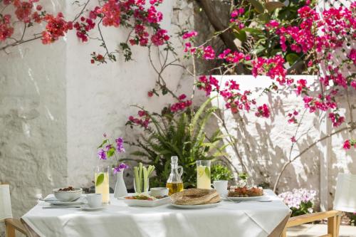 a table with food on it with pink flowers at Hotel Leto Hydra in Hydra