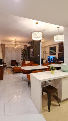 Una sala de estar con una mesa y sillas blancas. en 3Br Sky House BSD Apartment Brandnew and Cozy, en Samporo