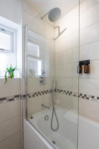 a bathroom with a shower and a bath tub at Prime Location Cardiff Pontcanna Modern 2 Bedroom Apartment with Privat Parking in Cardiff