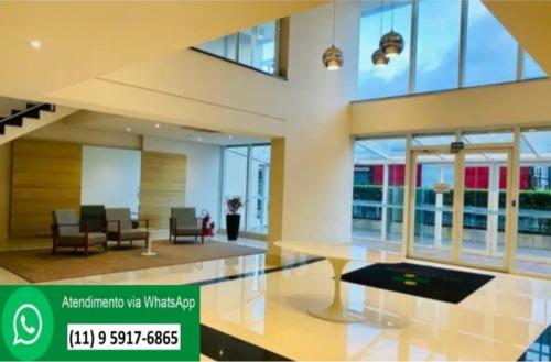 a lobby with a table and chairs in a building at Terraço Harmony Flats GRU in Guarulhos