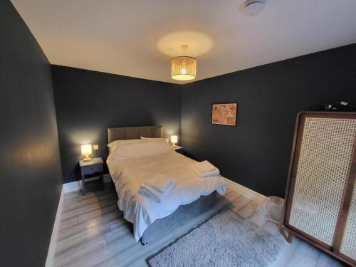 1 dormitorio con cama y pared negra en Teresa's Cottage en Kilcolgan