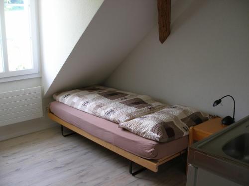 a small bed in a corner of a room at Gasthof Rössli in Wyssachen