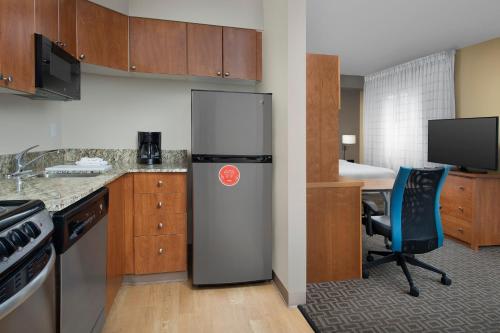 eine Küche mit einem Kühlschrank und einem Tisch im Zimmer in der Unterkunft TownePlace by Marriott Suites Portland Vancouver in Evergreen