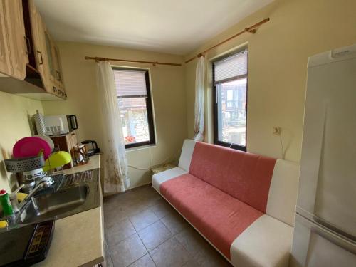 ein Wohnzimmer mit einer rot-weißen Couch in einer Küche in der Unterkunft Apartment in a beach house Old town Nessebar in Nessebar