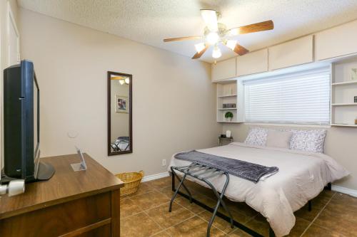 a bedroom with a bed and a ceiling fan at Home with pool near Sea World & Lackland in San Antonio