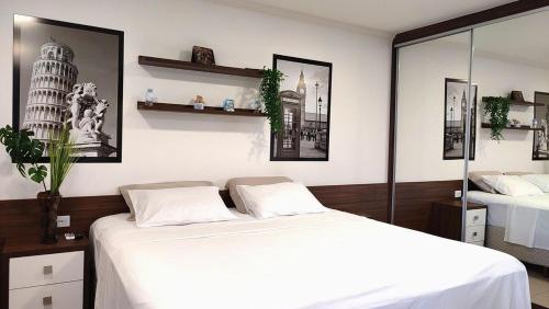 a bedroom with two beds and two pictures on the wall at Lindos Studios Centro/Wifi/Garagem in Foz do Iguaçu