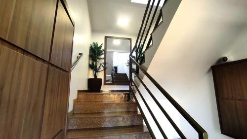 a hallway with stairs with a door and a plant at Lindos Studios Centro/Wifi/Garagem in Foz do Iguaçu