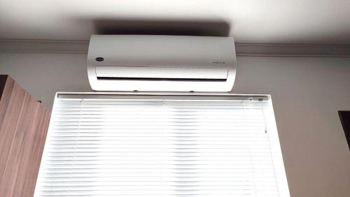 a air conditioner hanging from a ceiling next to a window at Lindos Studios Centro/Wifi/Garagem in Foz do Iguaçu
