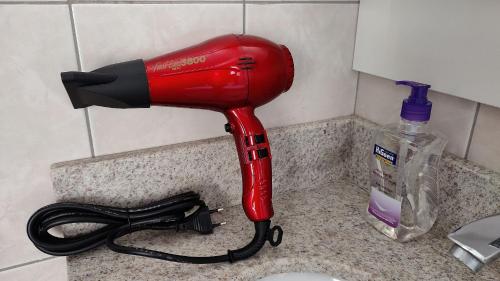 a blow dryer sitting on a counter next to a sink at Lindos Studios Centro/Wifi/Garagem in Foz do Iguaçu