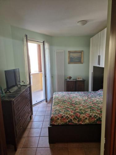 ein Schlafzimmer mit einem Bett, einer Kommode und einem TV in der Unterkunft Appartamento Rosy in Rimini