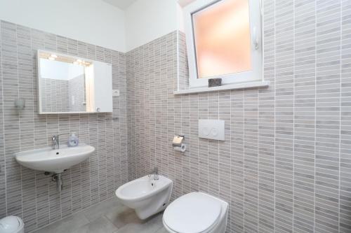 een badkamer met een toilet en een wastafel bij Villa Tia, with jacuzzi, barbecue & green oasis in Opatija