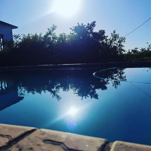 a pool with the sun reflecting in the water at Kings View Exclusive Villas (KVEV) in Petronella