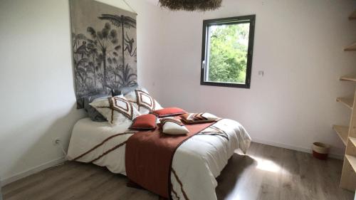 Kleines Zimmer mit einem Bett, einem Fenster und einem Fenster. in der Unterkunft Maison moderne et écologique in Varaire