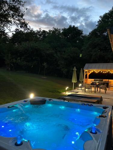 een zwembad in een tuin 's nachts bij Lodge avec spa au coeur de Brocéliande in Beignon