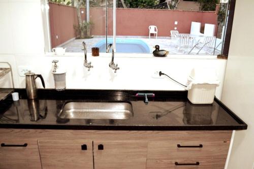 a kitchen sink with a view of a patio at Nova, piscina exclusiva, 350 m. de Camburizinho in Camburi