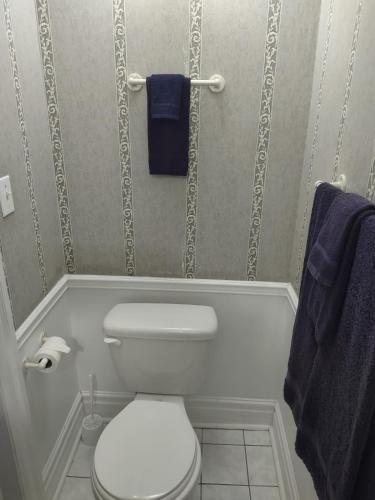 a bathroom with a white toilet and blue towels at The King George Inn in Cobourg