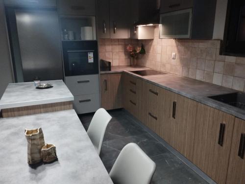 a kitchen with a table and white chairs in it at Luxury Apartment in Dhamoulianáta