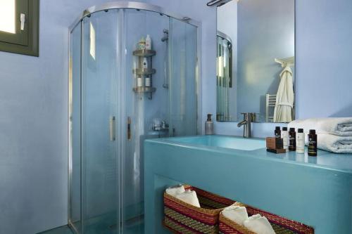 a bathroom with a glass shower and a sink at Villa Kanaki 