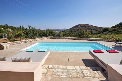a swimming pool in a villa with mountains in the background at Villa Kanaki in Galatás