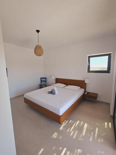 a white bedroom with a bed and a window at Villa Milan 1 mit Padelplatz in Kos Town