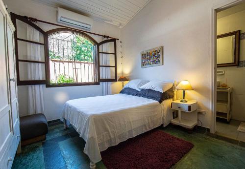 um quarto com uma cama e uma janela em Piscina e 3 dorm. a 150 m de Camburizinho em Camburi