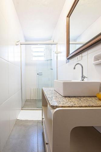 a bathroom with a sink and a shower at Piscina e 3 dorm a 150 m de Camburizinho in Camburi