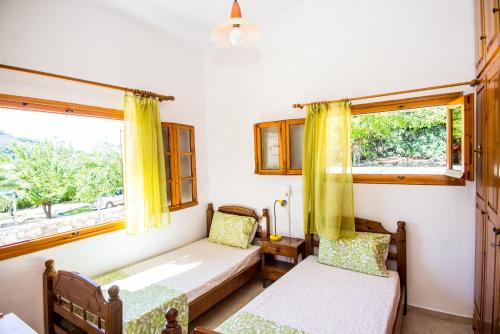 a room with two beds and a window at Tzatzaminia Cottage in Argostoli