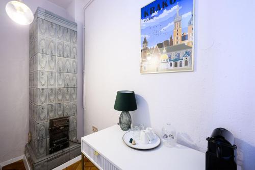 a white room with a table with a lamp on it at Wiślna Main Square Apartments in Krakow