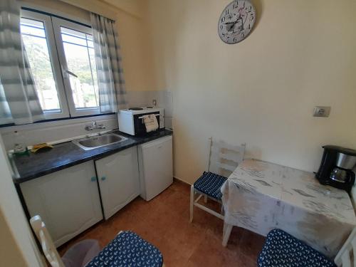 a small kitchen with a sink and a microwave at Studios Eftichia in Fournoi