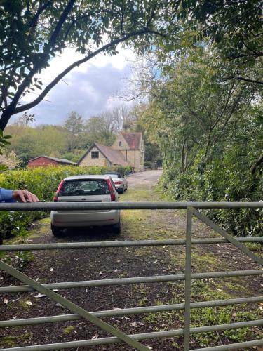 a car parked on a road next to a fence at South Lodge House in Dormans Land
