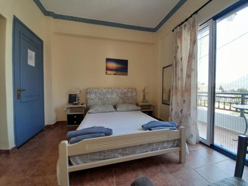a bedroom with a bed and a large window at Studios Eftichia in Fournoi