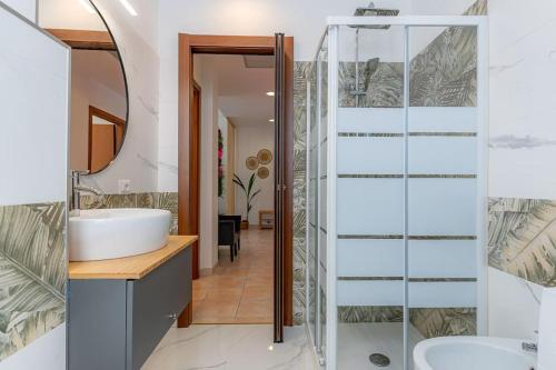 uma casa de banho com uma cabina de duche em vidro e um lavatório. em [Rio's] cozy apartment in the heart of Como em Como