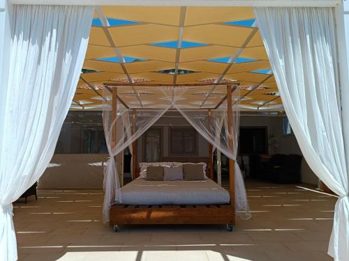 un letto sotto un baldacchino in una stanza con tende di Maria Apartments a Zaton