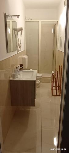 La salle de bains est pourvue d'un lavabo, de toilettes et d'un miroir. dans l'établissement B&B Elios Rooms, à Catane