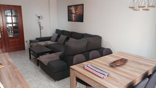 sala de estar con sofá y mesa en Apartamento A Atalaia, en Laxe