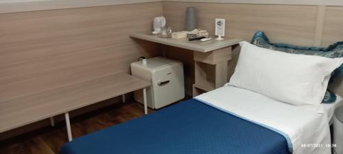 Habitación pequeña con cama y escritorio pequeño. en B&B Elios Rooms, en Catania
