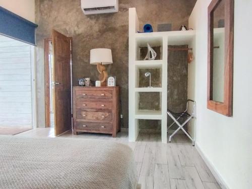 a bedroom with a bed and a dresser and a mirror at Hostel-Island Paradise, Saboga Lodge and Villa Noelia in Panama City