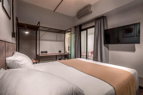 a hotel room with a bed and a flat screen tv at Up Barrio Norte in Buenos Aires