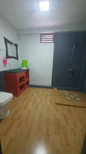 a room with a bathroom with a toilet and a wooden floor at The river lake villa in Unawatuna