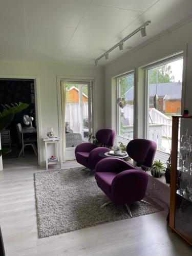 a living room with purple chairs and a table at Leilighet med 2 soverom in Rokland