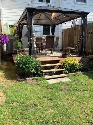 a patio with a black gazebo with a table and chairs at Chambre confortable in Sherbrooke
