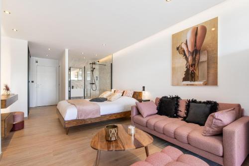 une chambre avec un lit, un canapé et une table dans l'établissement Village Naturiste R4N - Catalina Héliopolis Luxe, au Cap d'Agde