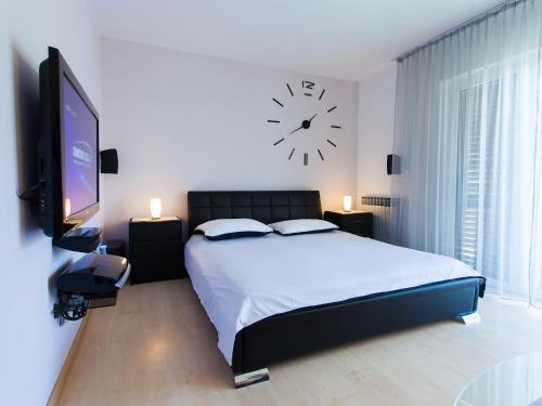 una camera con un letto e un orologio a muro di Apartments Sun Park a Poreč (Parenzo)