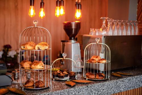 three bird cages with pastries in them on a counter at Hotel Vents Des Iles in Essaouira